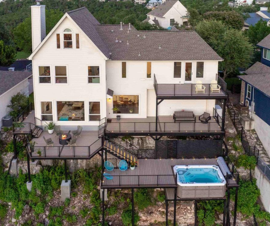 deck on the back of a house with three levels and a hot tub