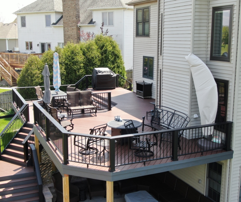 deck on the back of a house with patio furniture