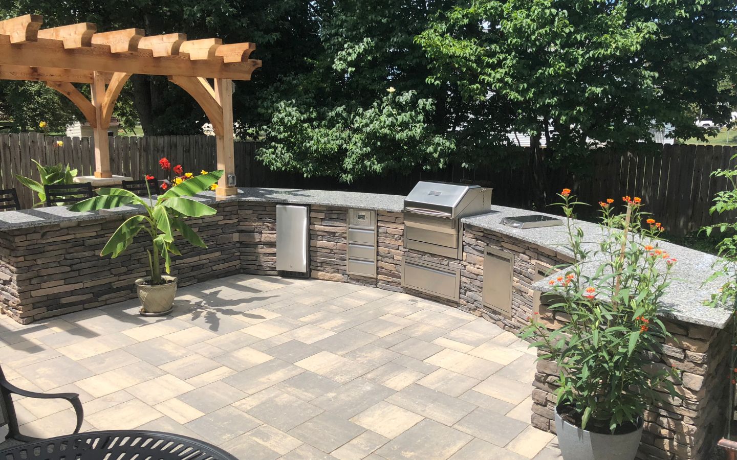 A patio with a grill and a pergola

AI-generated content may be incorrect.