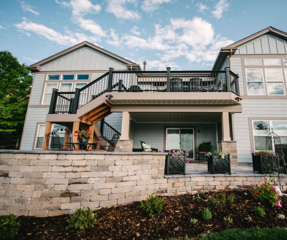 deck on the back of a house with a stone wall