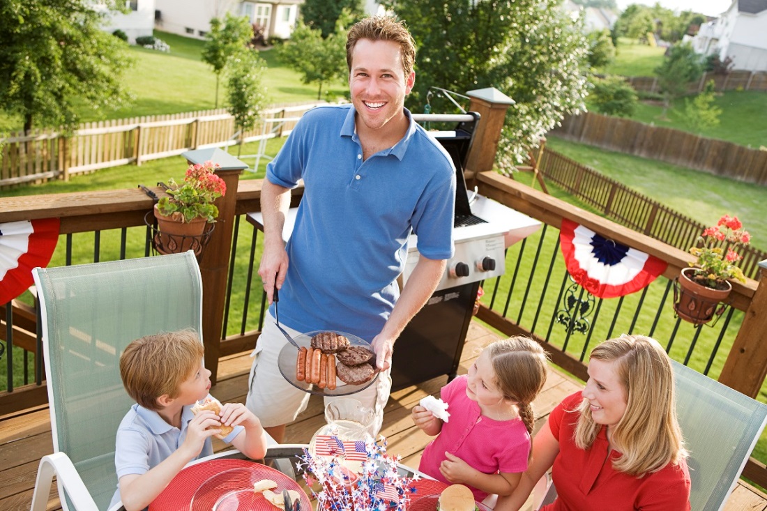 family on outdoor patio grilling food