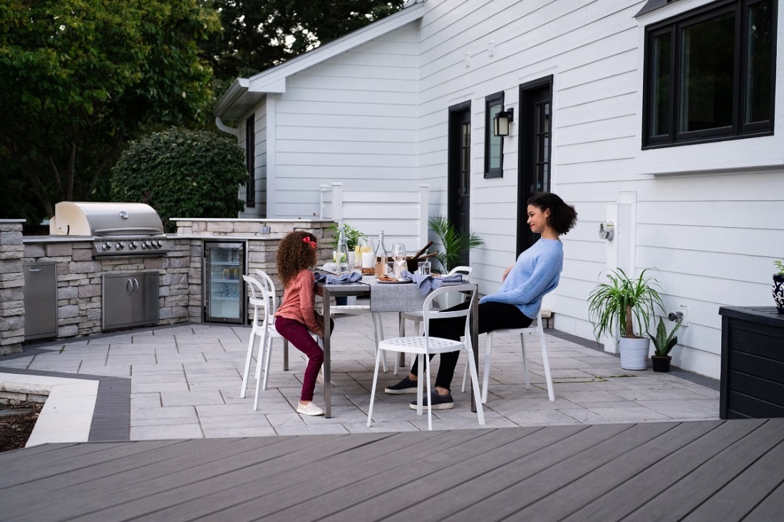 women and child sitting at an outdoor table near outdoor kitchen