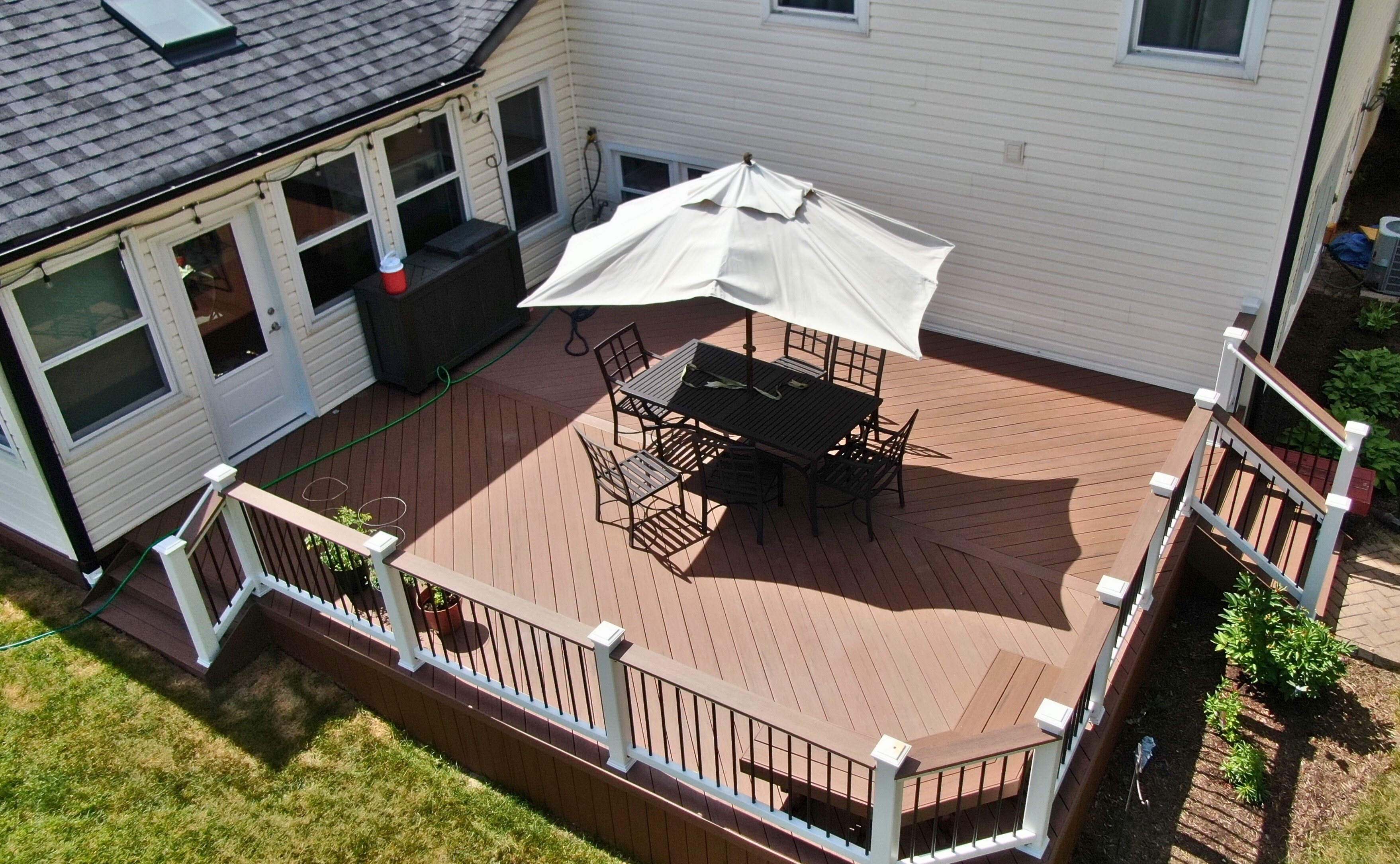 Custom natural wood deck in Wheaton, IL with a wrap-around design, full skirting to enclose the under-deck area, and steps leading to the yard.