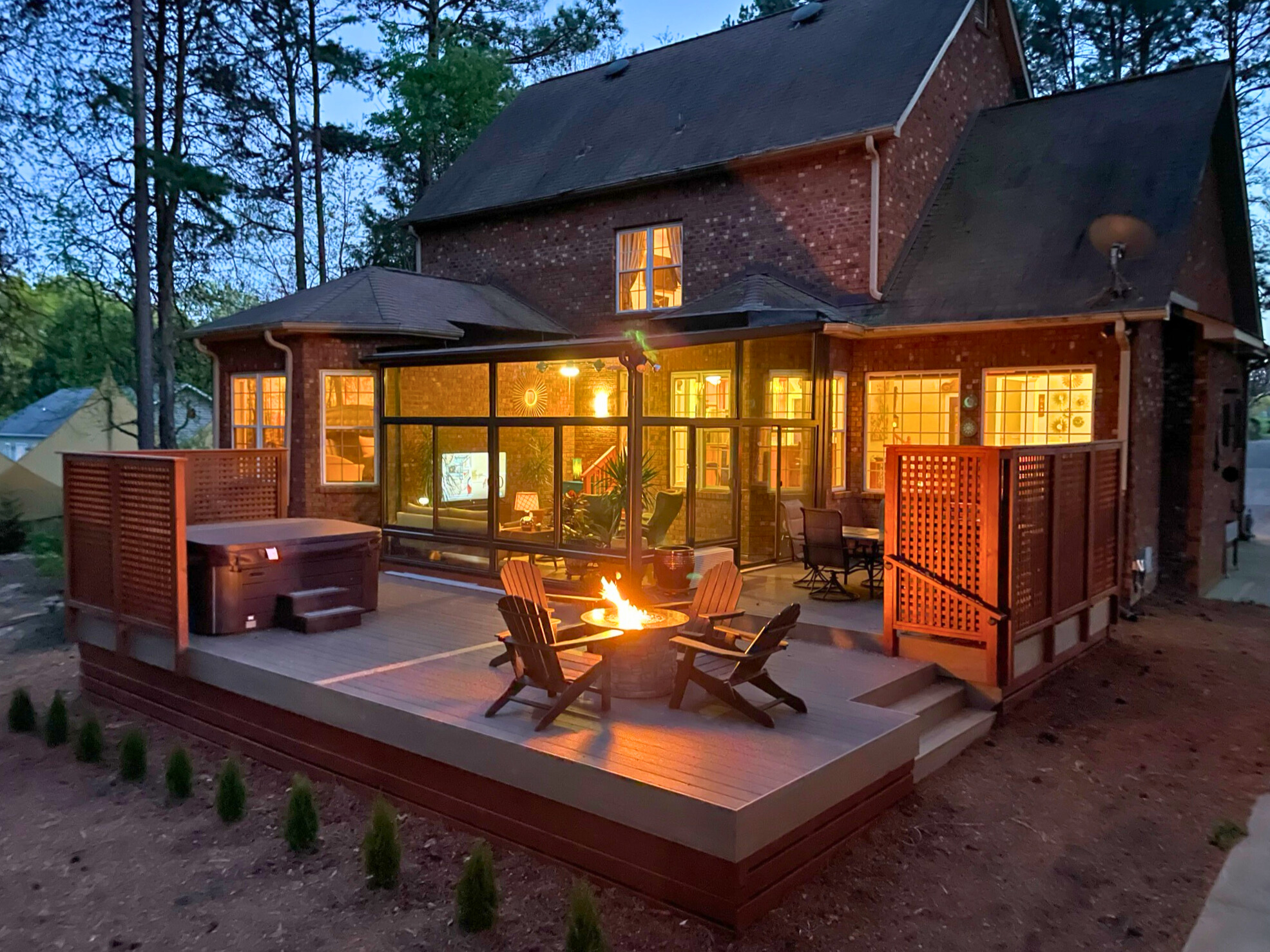 Custom composite deck and sunroom with fire pit and privacy walls in Denver, Nc.
