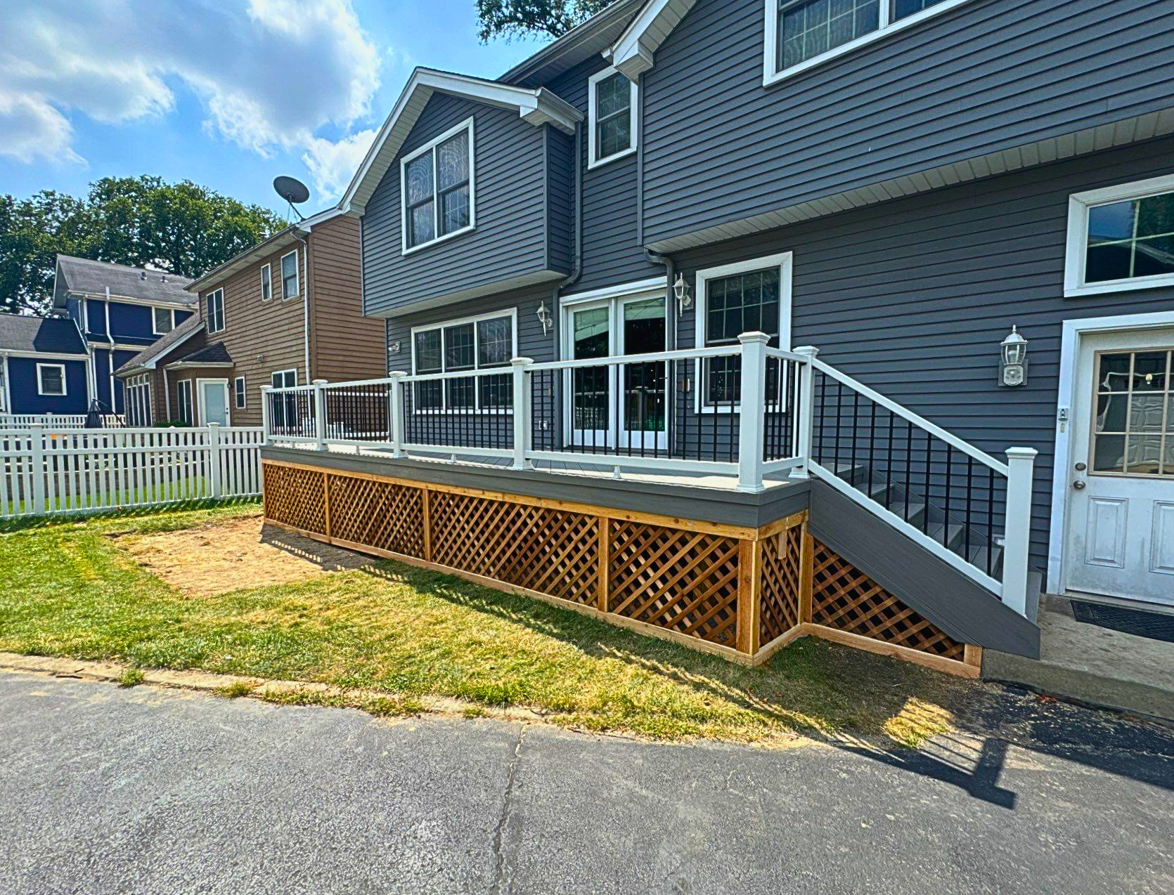 Gorgeous composite deck with white rails and wood lattice skirting in Elmhurst, IL..