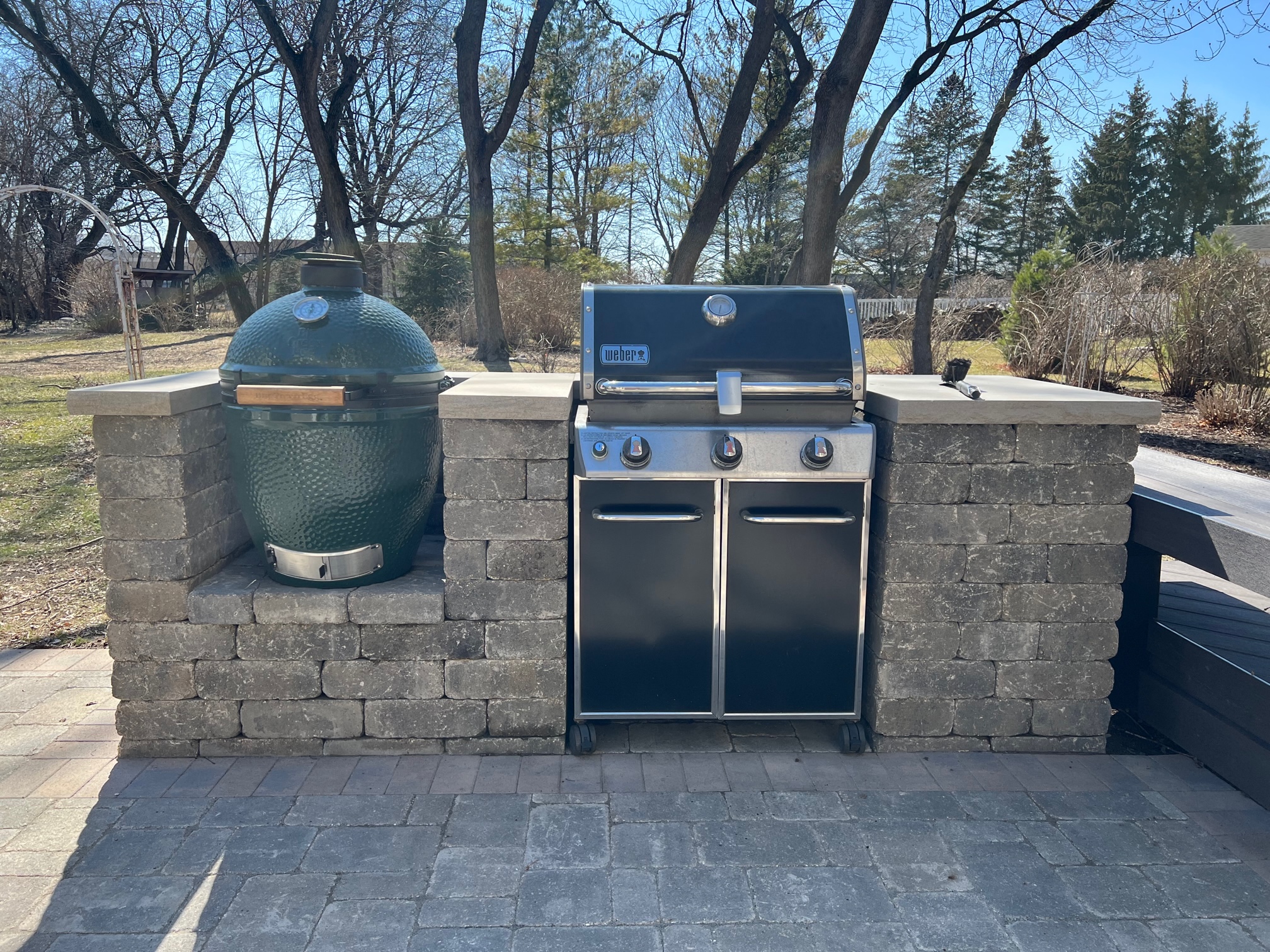 Custom paver grill surround with a green egg and weber grill by archadeck