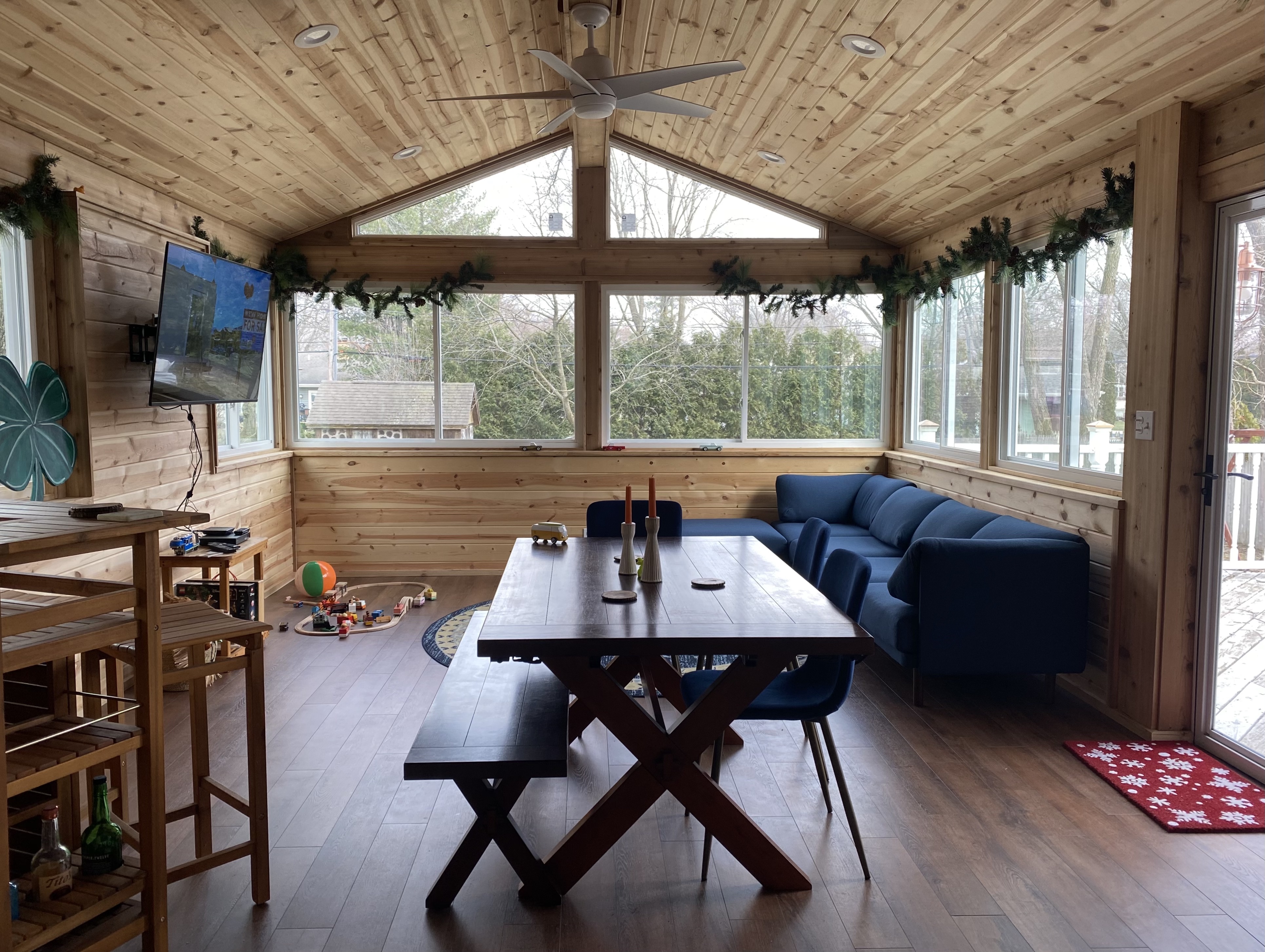 Cozy sunroom with dining table, tv, and couch.