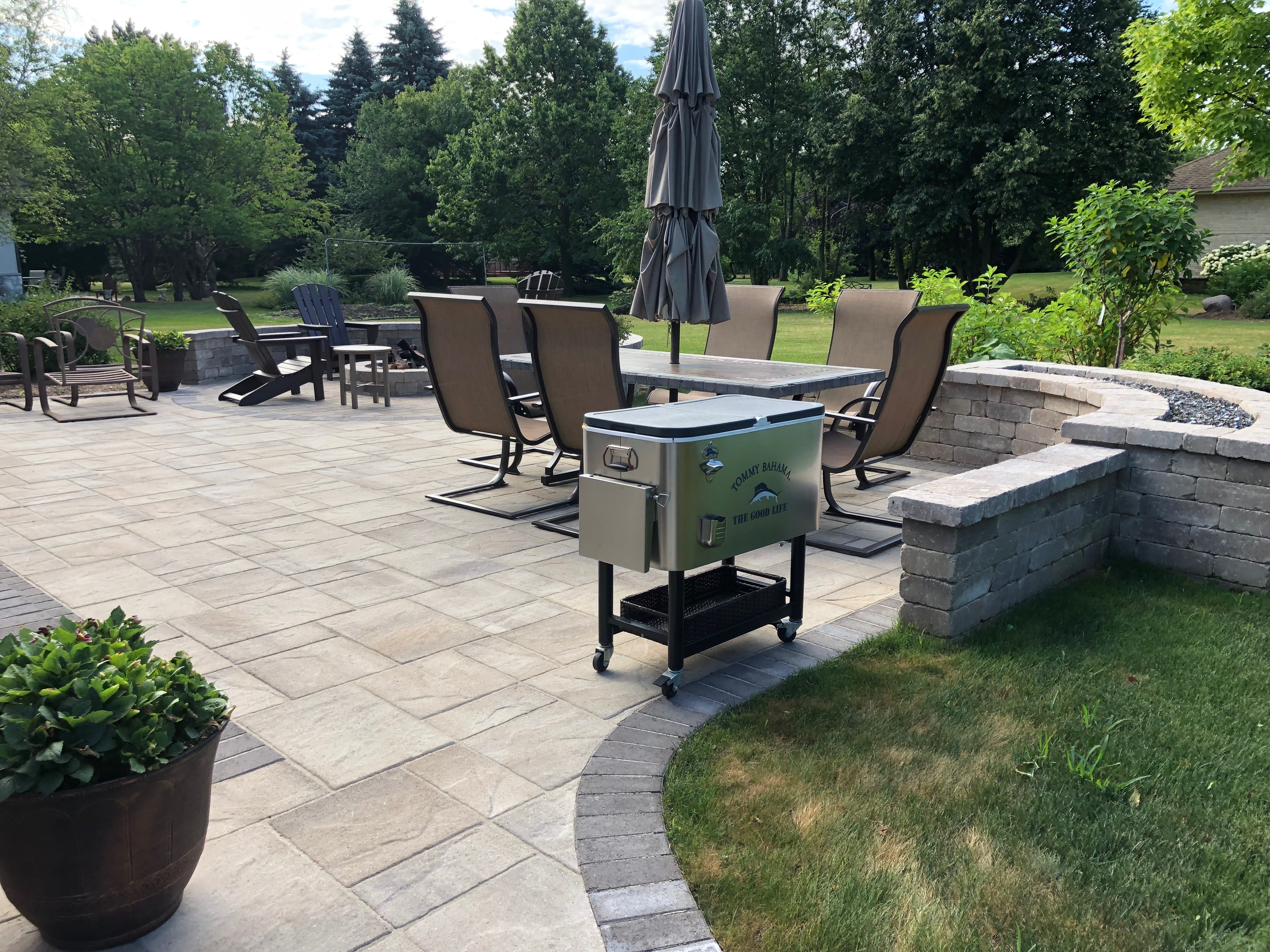 Custom paver patio featuring a built in seat wall and fire pit by patio builders, Archadeck of Chicagoland-Naperville.