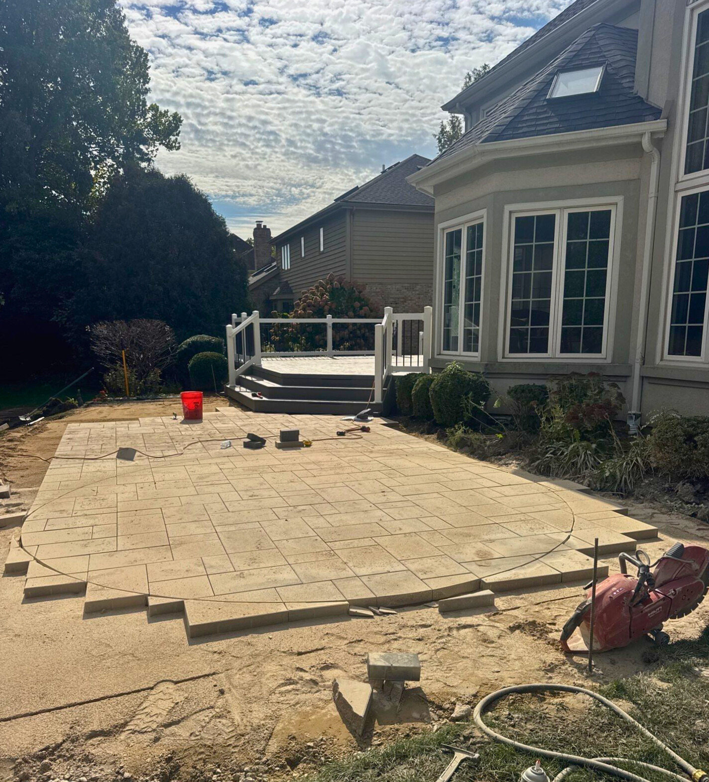 Progress of a paver patio being cut into a circle shape.