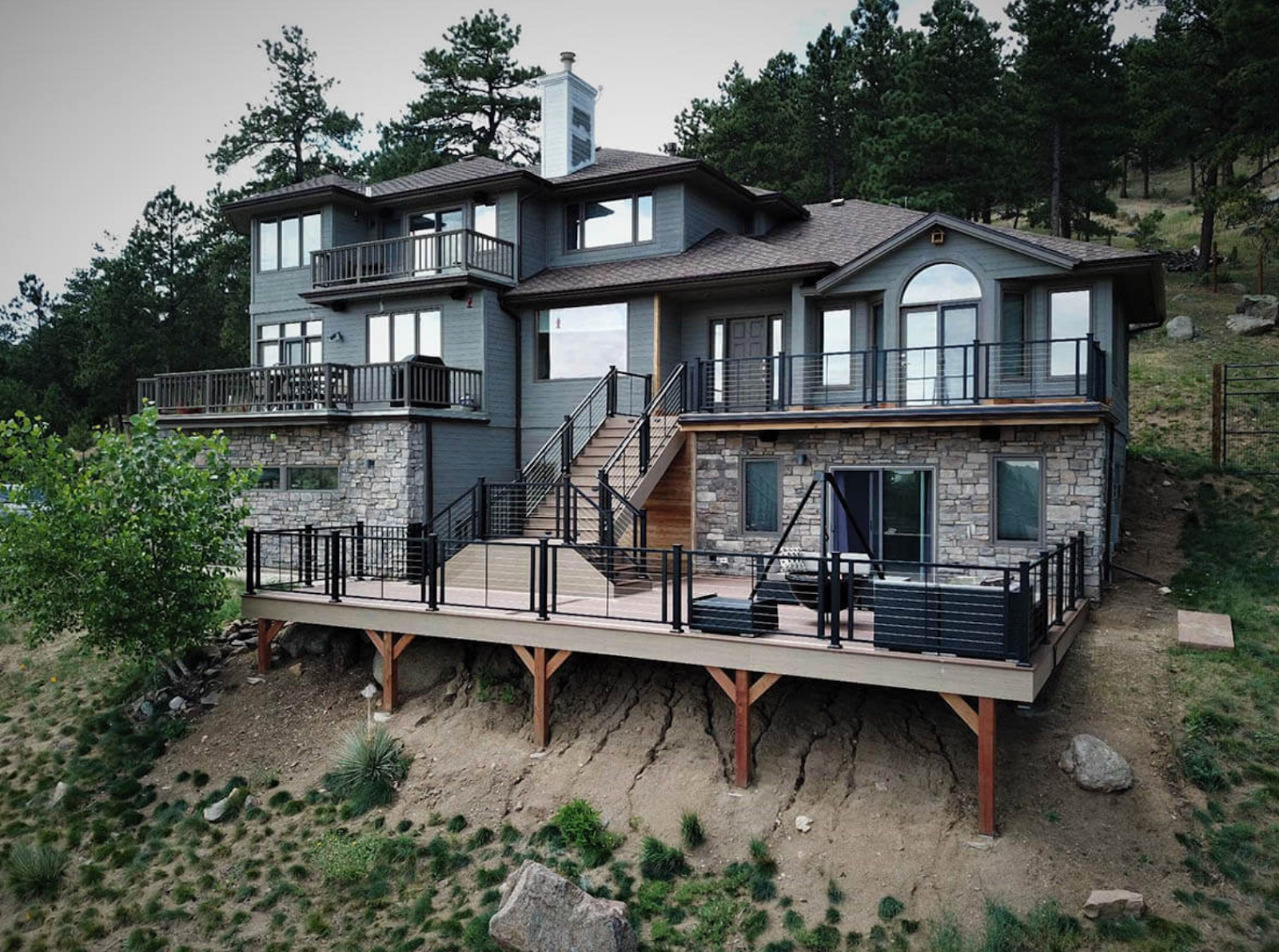 back of a home with wood deck and black railings