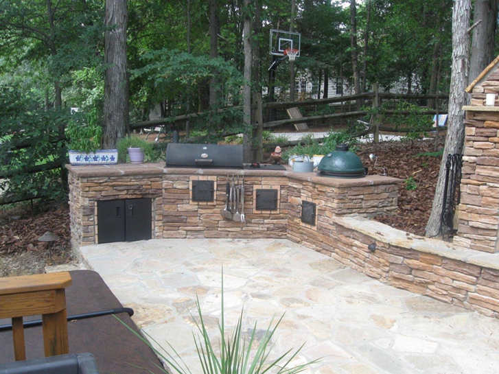 Premium stone veneer outdoor kitchen built on a composite deck with a stainless-steel grill and Big Green Egg, Charlotte, NC.