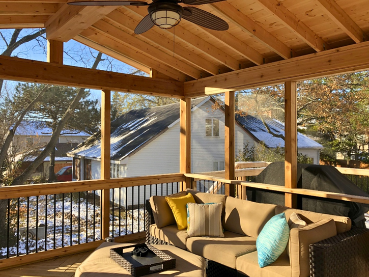 Screened porch in Lake Zurich, Illinois, with vaulted wooden ceiling, ceiling fan, and comfortable outdoor furniture.