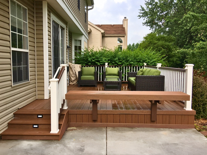 Custom composite deck in Lake Zurich, Illinois, with built-in bench seating and white railings.