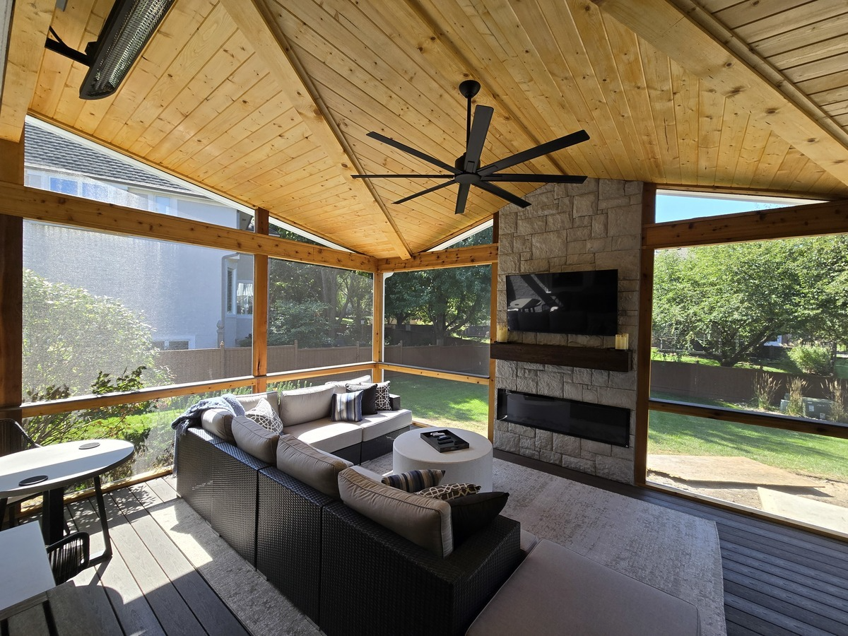 Wood covered patio with stone fireplace and seating