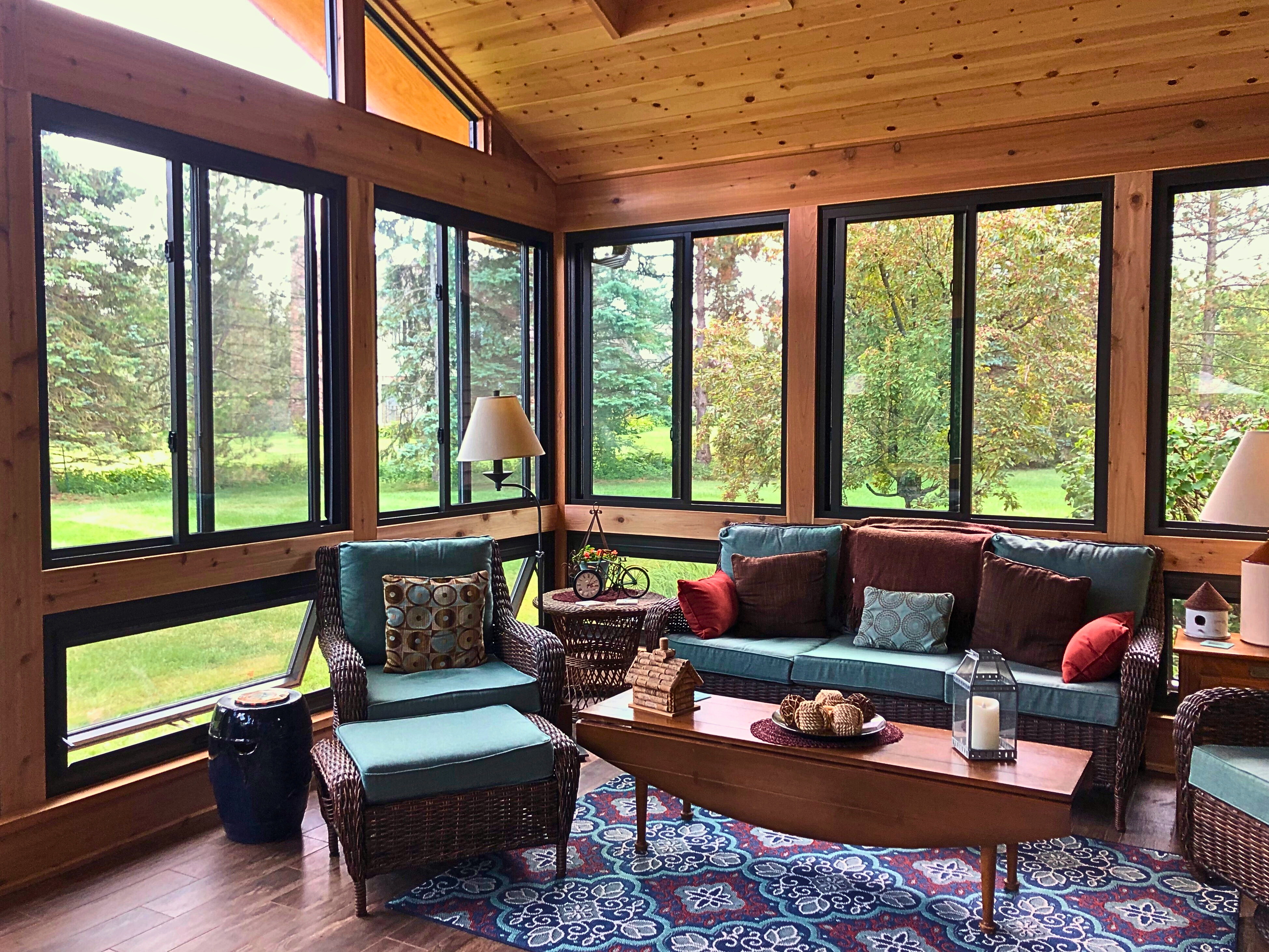Inside of a gorgeous cedar sunroom with black windows built by sunroom builder, arcahdeck of chicagoland-naperville.