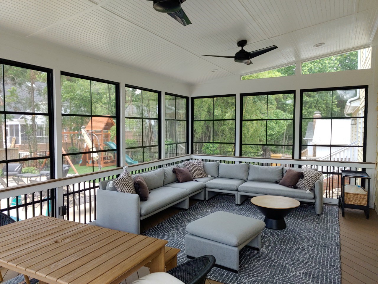 Inside of a custom sunroom design with 4-track windows in Charlotte, NC.