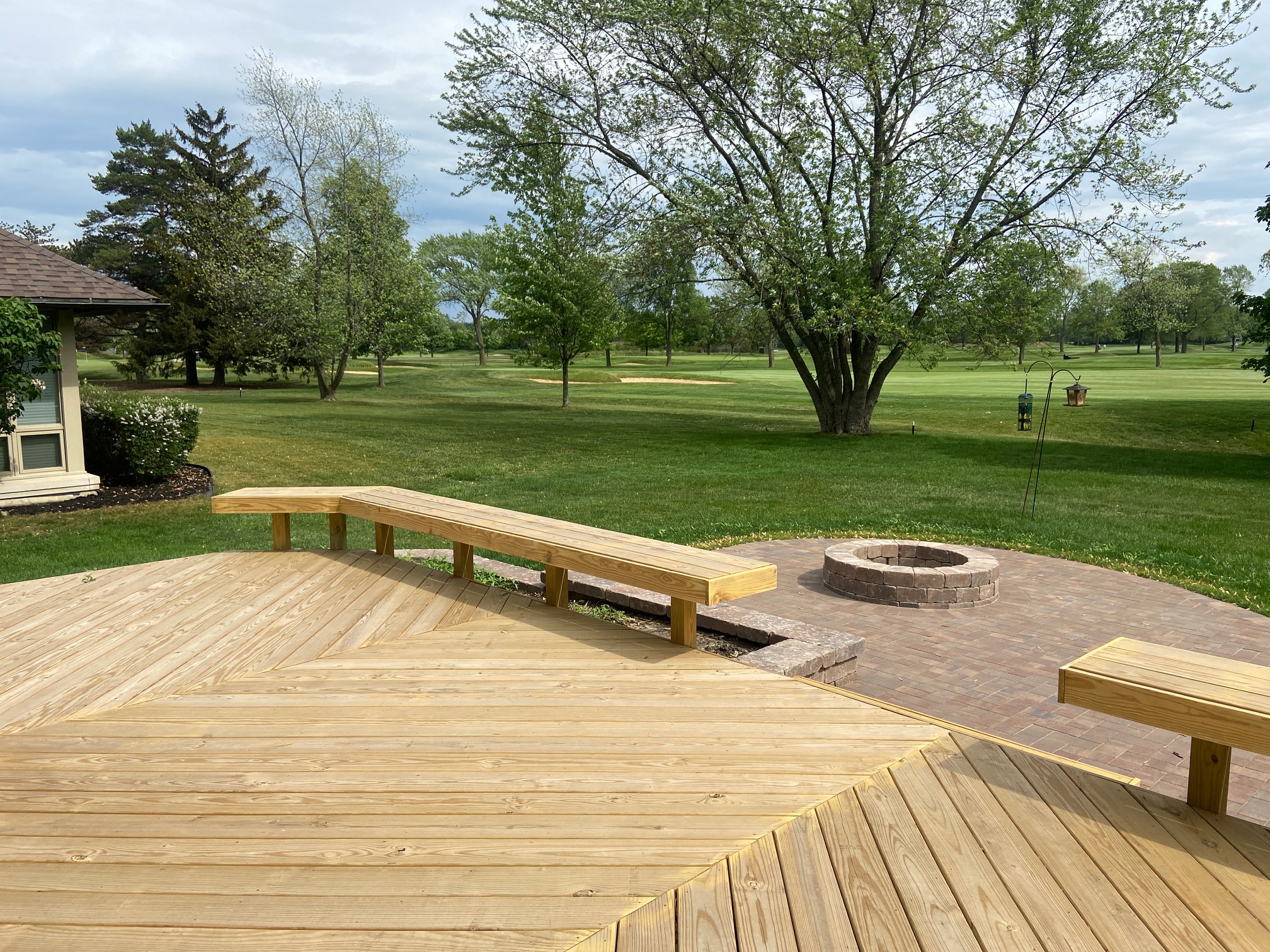 Custom wood deck with built-in benches and a paver patio with firepit in Deer Park, IL.
