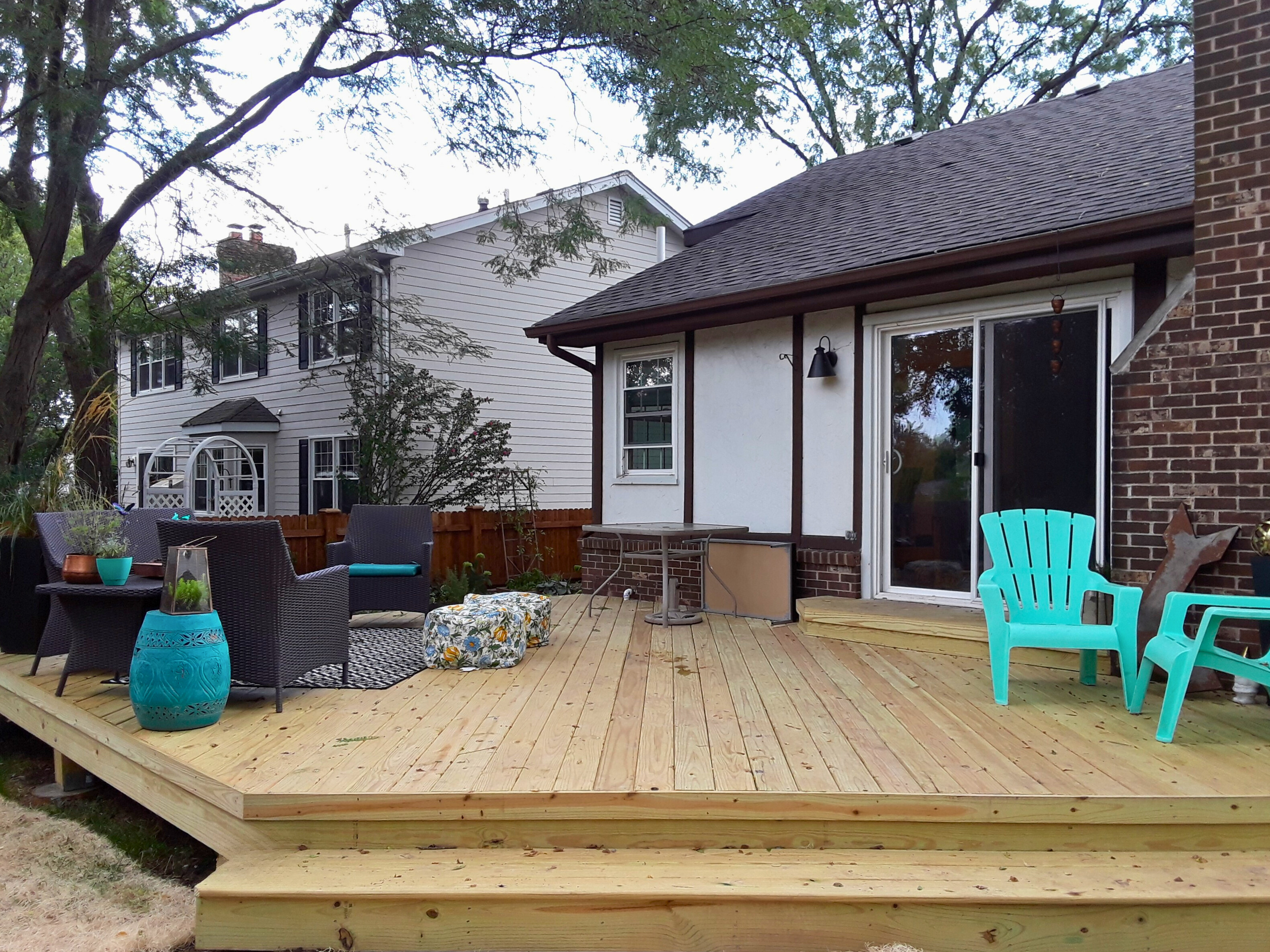 A large, ground-level wood deck with outdoor furniture, completed by a Woodridge wood deck builder.