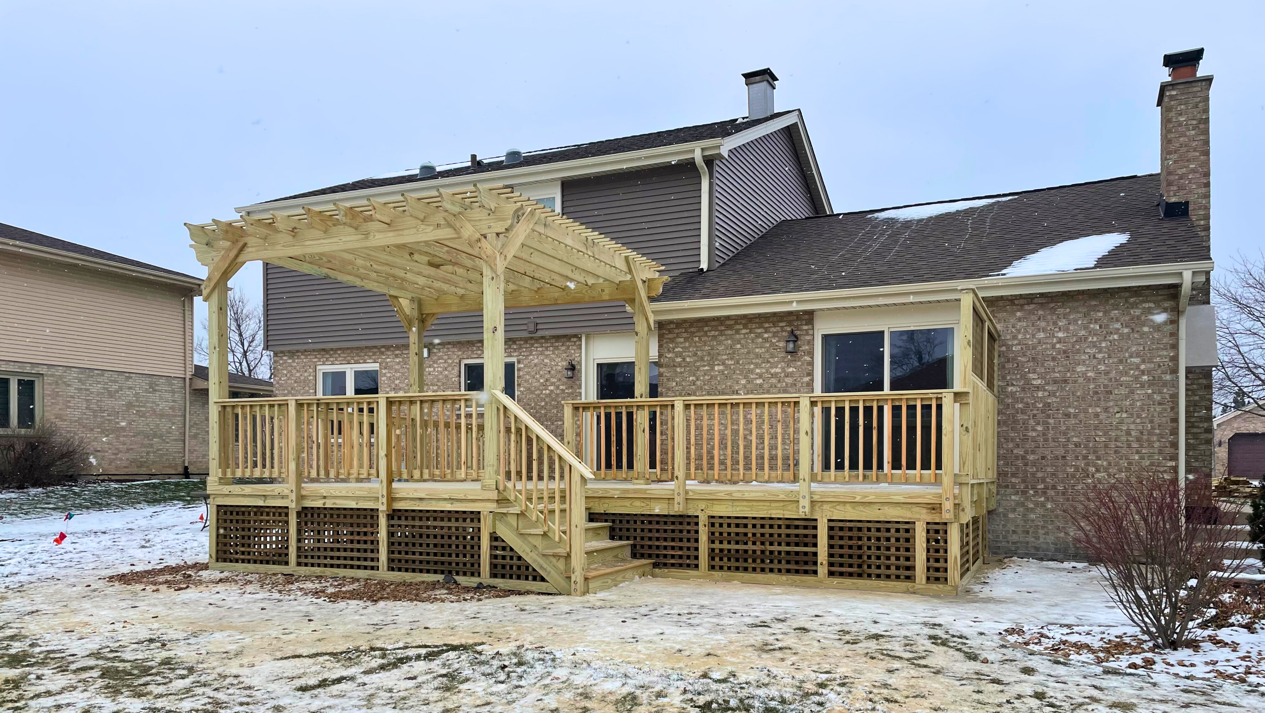 A new wooden deck with an attached pergola and lattice skirting, a custom project by a skilled Woodridge deck builder.