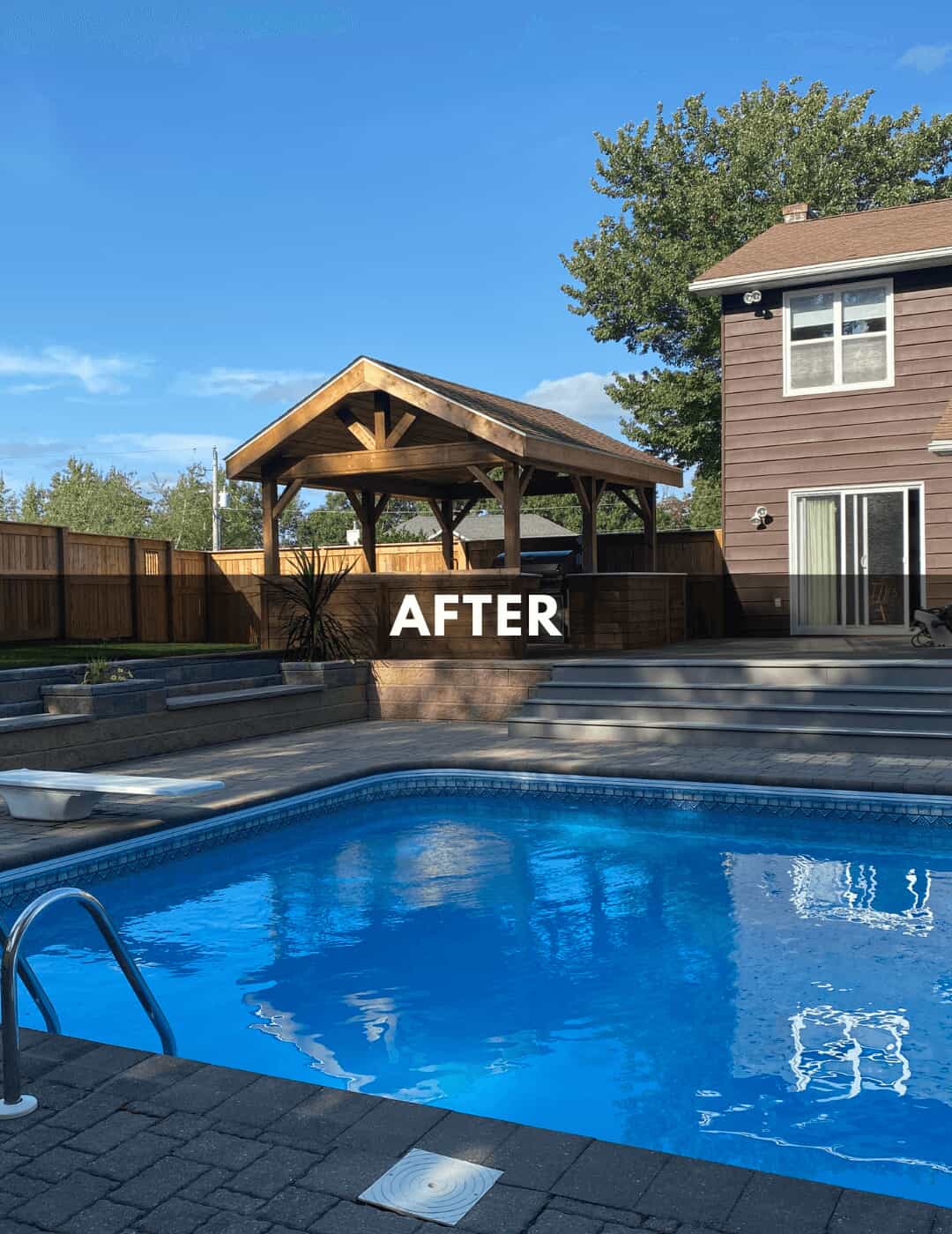 After photo of the outdoor kitchen, retaining wall, and deck, as viewed from pool side
