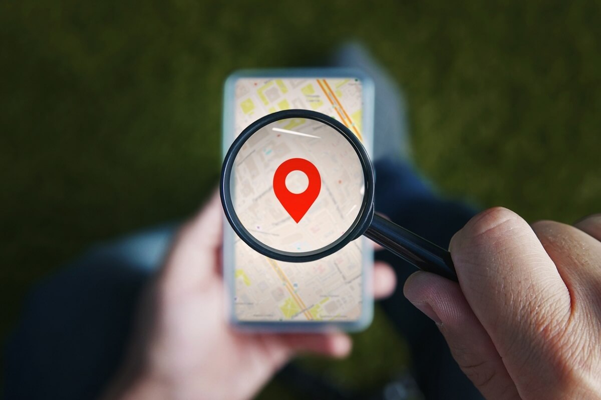 Magnifying glass over phone with location pin