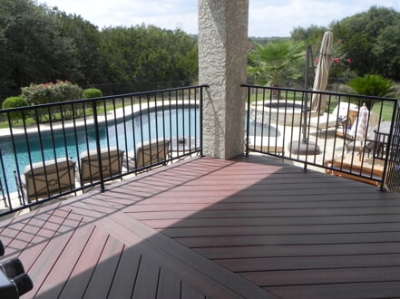 custom deck with railing overlooking pool 
