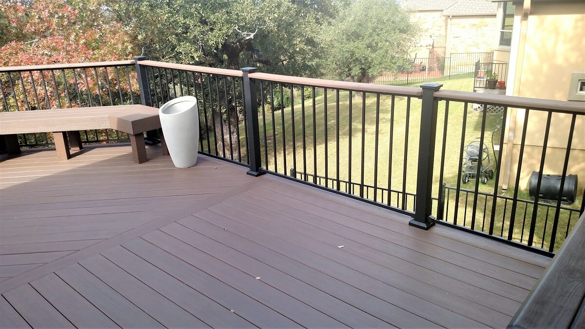 Backyard wood deck with railing and floating bench