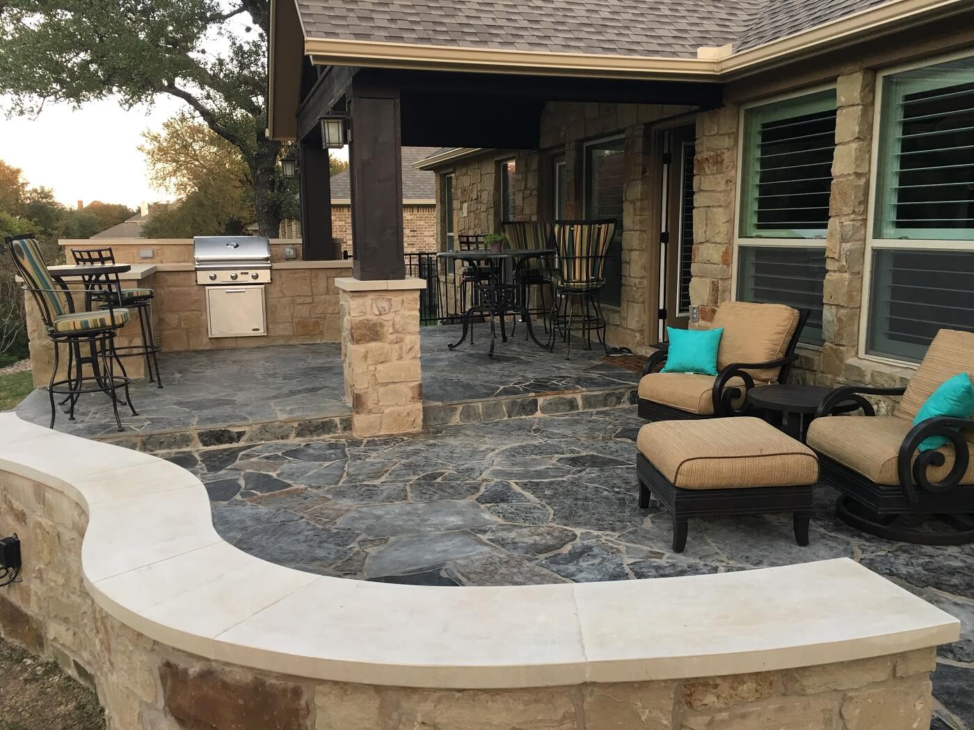 Covered and open patio with outdoor kitchen and seating area