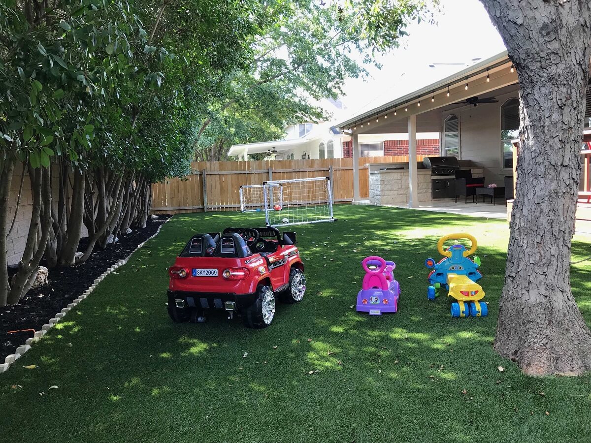 Backyard with parked toy cars and kiddie football area