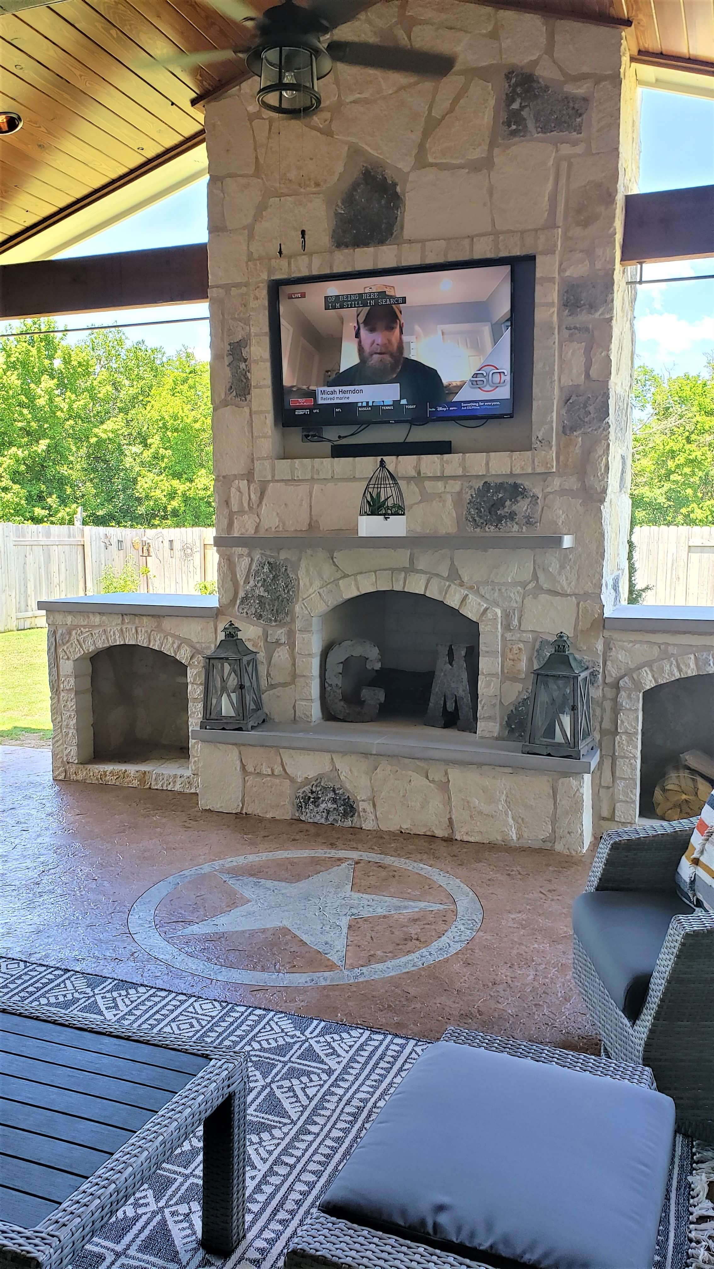Custom outdoor fireplace with mounted flat TV