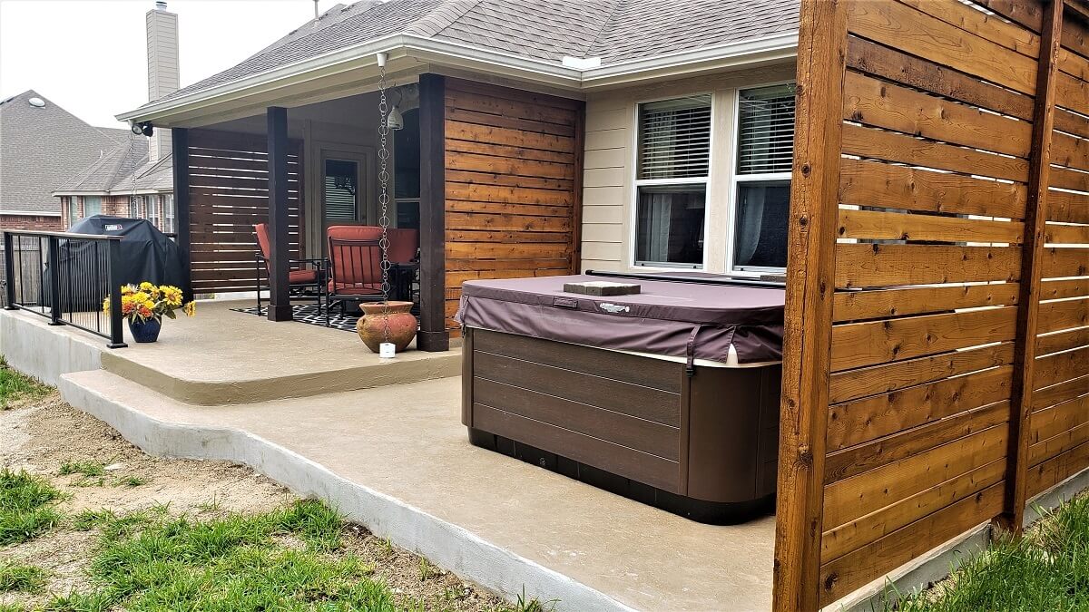 Custom covered patio with seating area and hot tub
