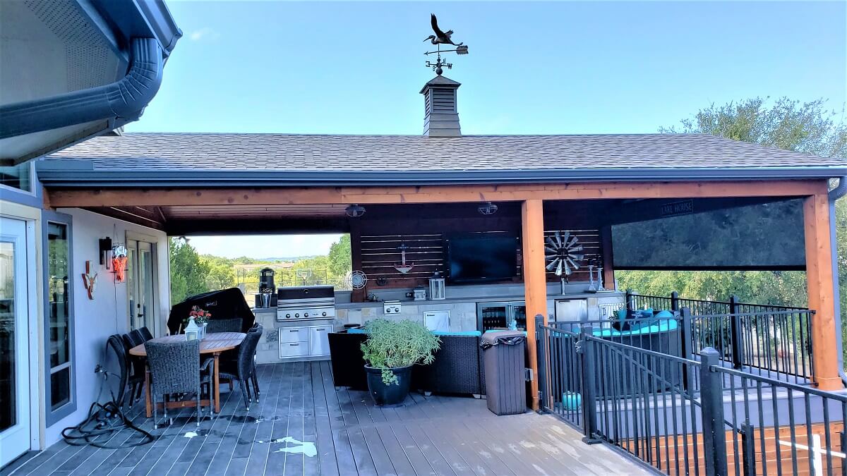 -Covered deck and patio with outdoor kitchen and dining area
