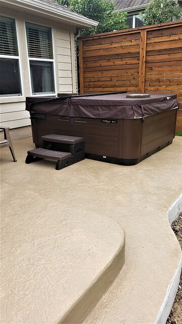 Custom hot tub on patio with privacy wall