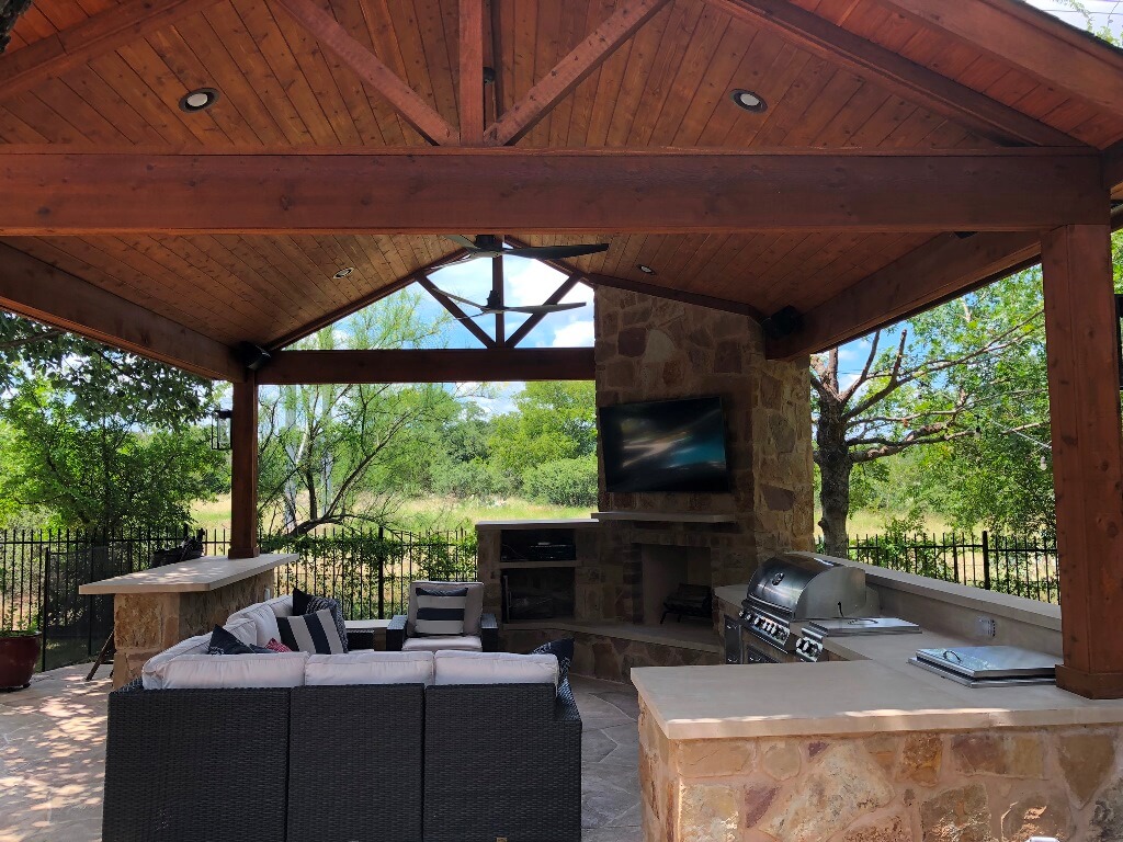 Poolside cabana with outdoor fireplace, outdoor kitchen, seating area and bar counter