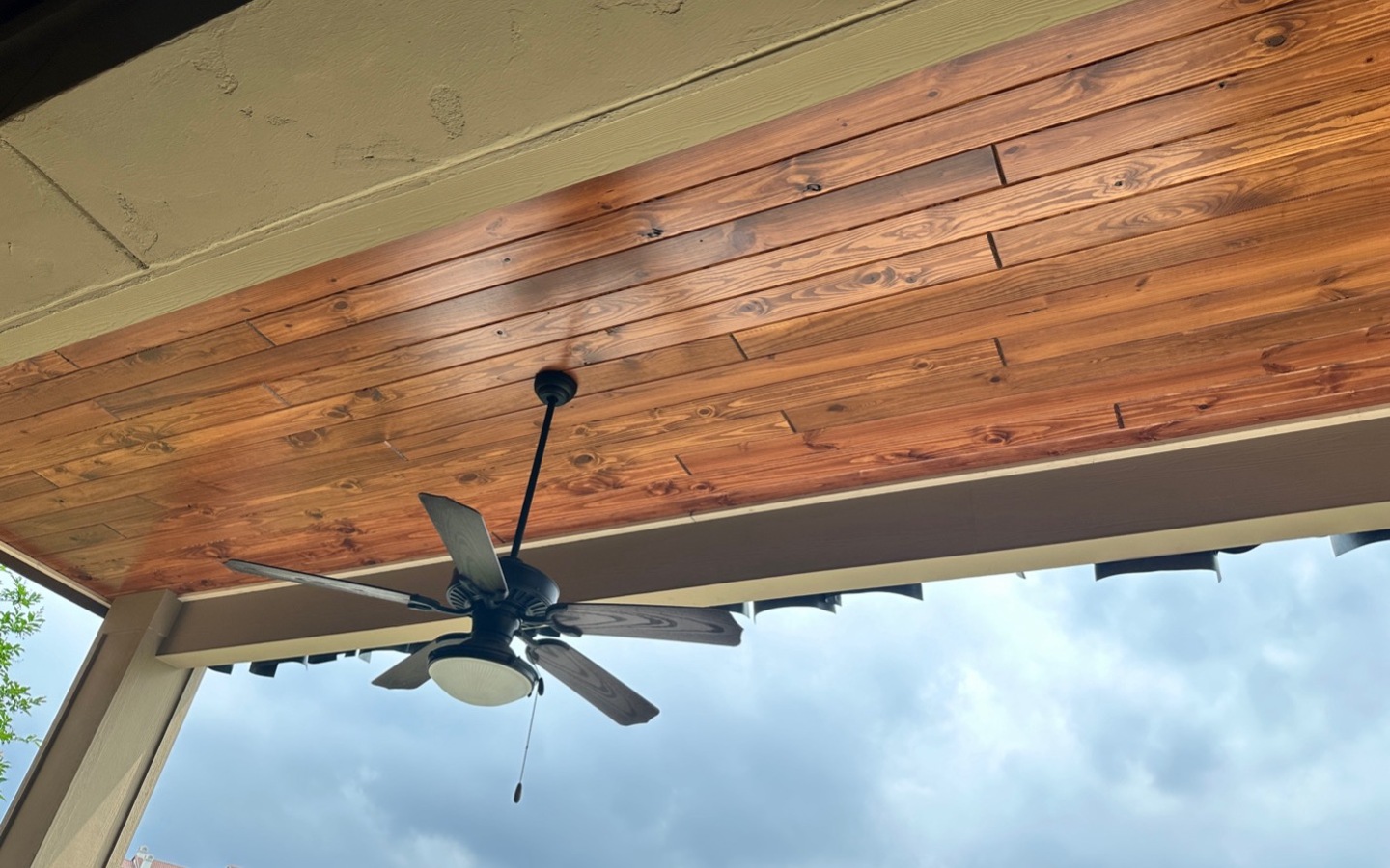 A ceiling fan on a porch

Description automatically generated