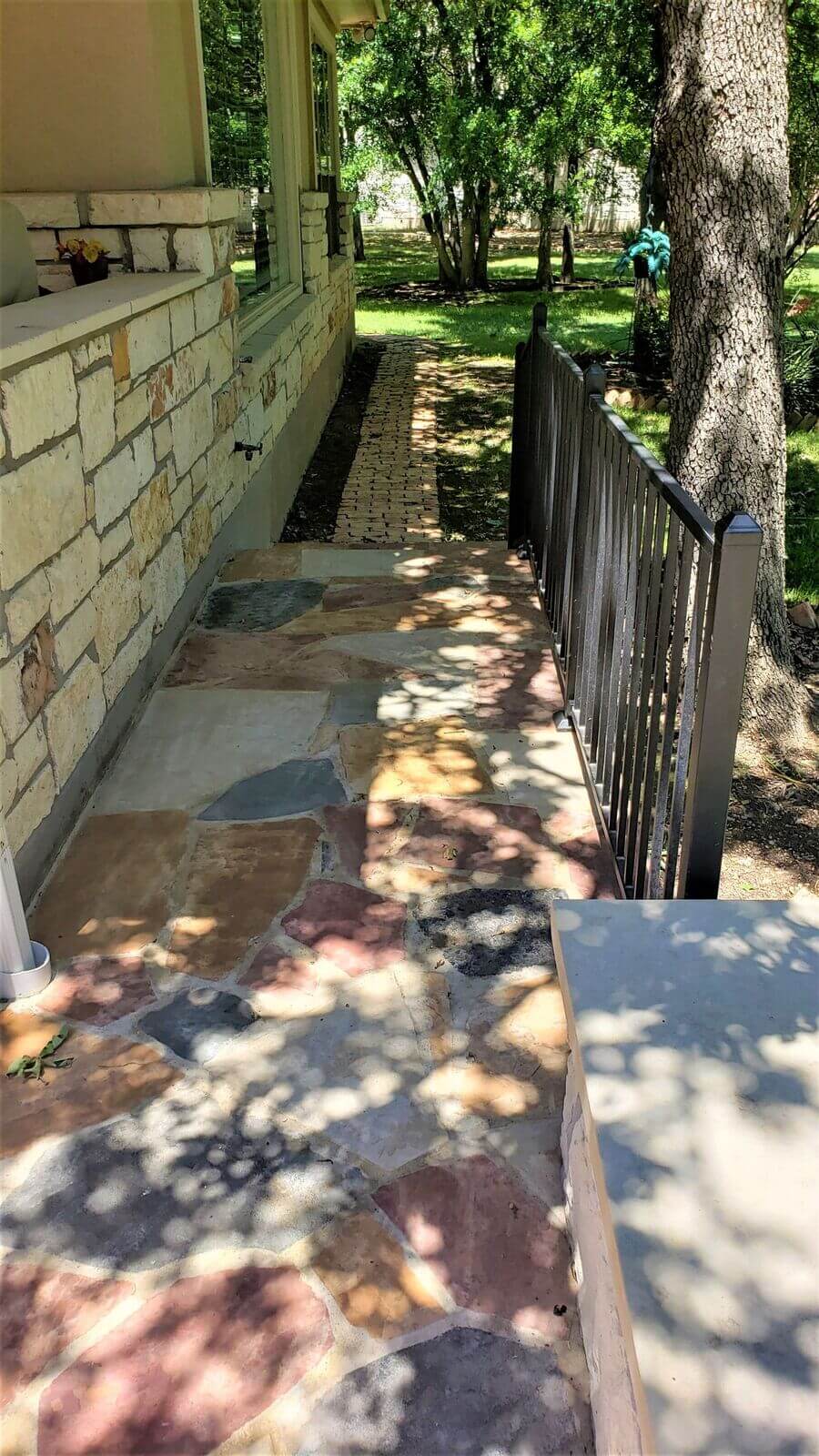 Extended side yard area of flagstone patio with railing