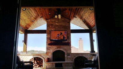 covered porch with mounted tv and fireplace 