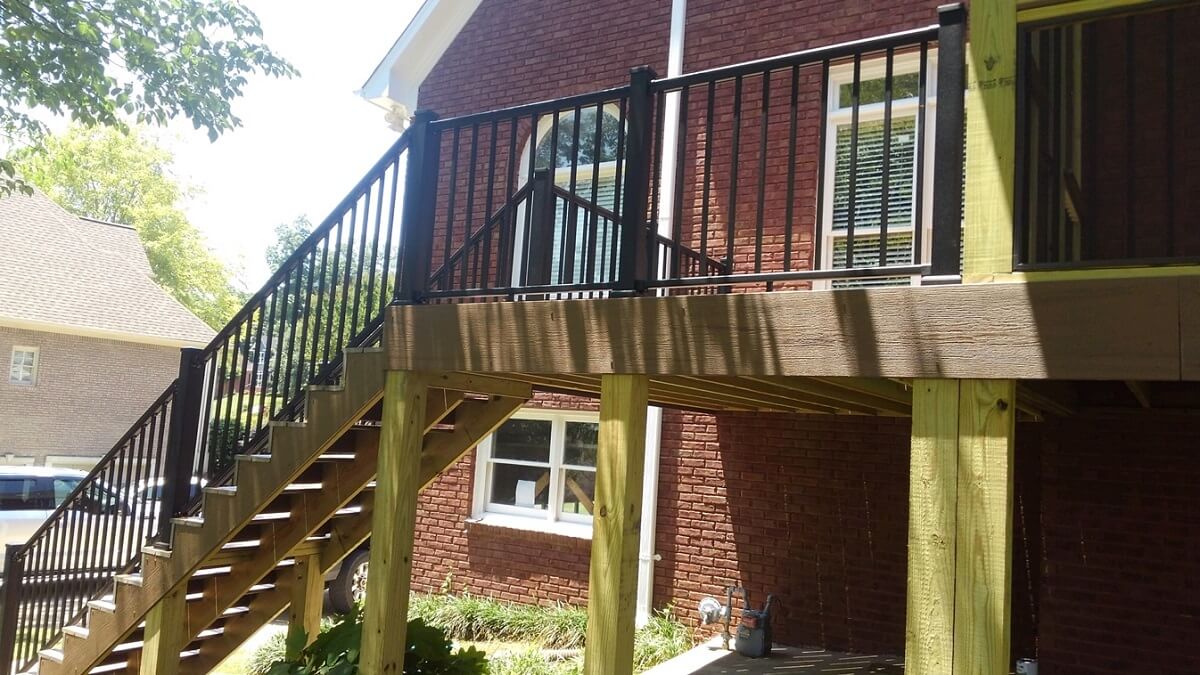 Custom backyard wood deck with railing and staircase