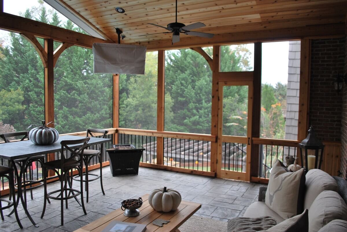 Screened porch with dining area, ceiling fan and mounted flat TV