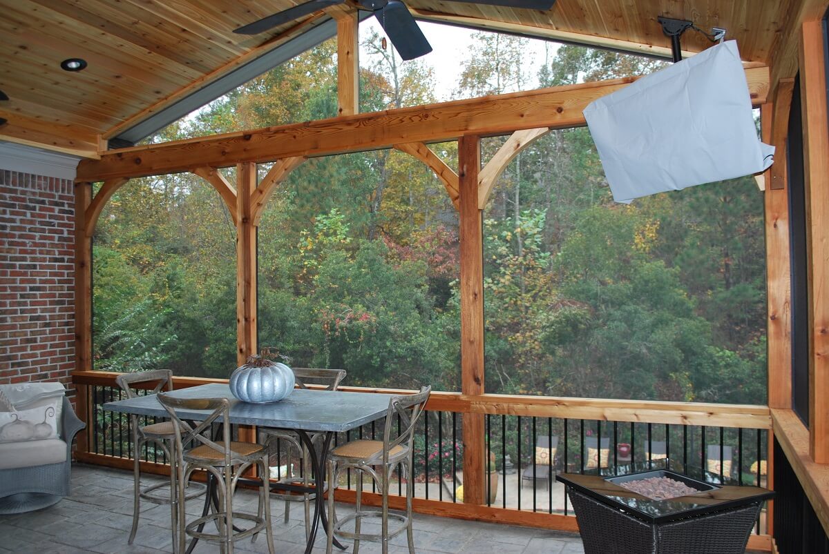 Interior of screened porch with dining area and silver pumpkin decor on table