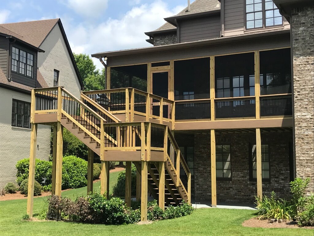 Custom backyard screened porch and wood deck with staircase