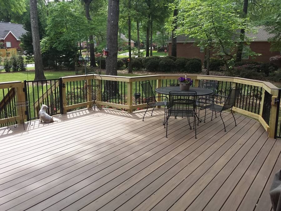 Backyard wood deck with seating area and dog seating near deck gate