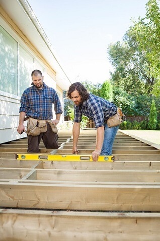 Workers measuring wood for deck
