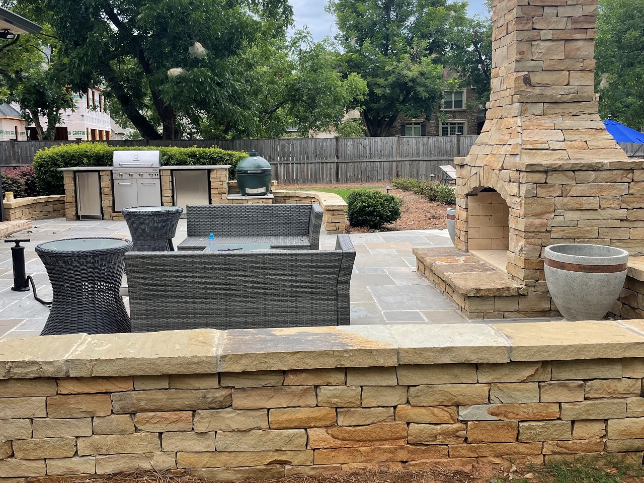 hardscape patio with furniture and fireplace