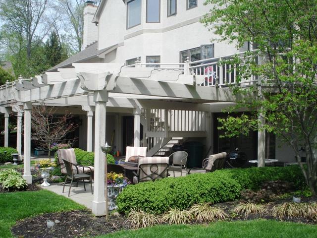 White pergola with deck and patio furniture