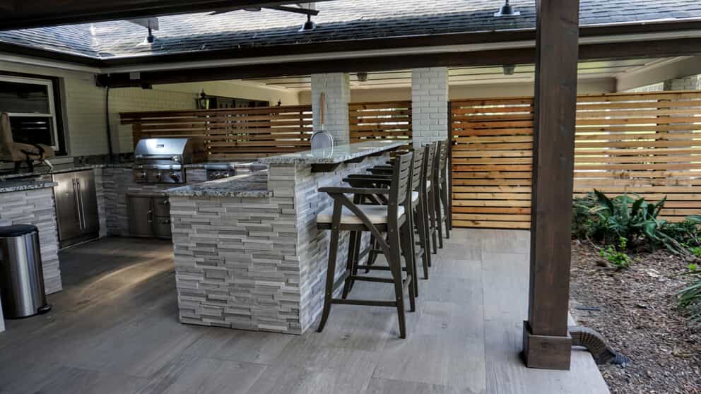 Outdoor kitchen under covered area with bar seating