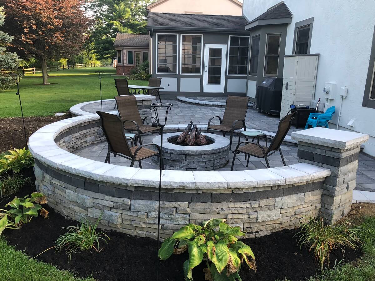 Custom backyard patio with fire pit and retaining wall