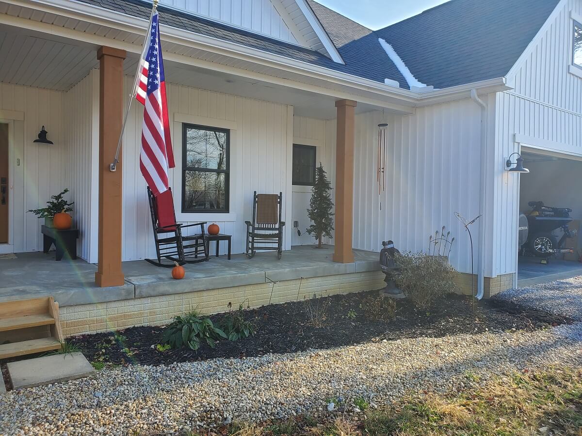 Old front porch with seating area and American flag