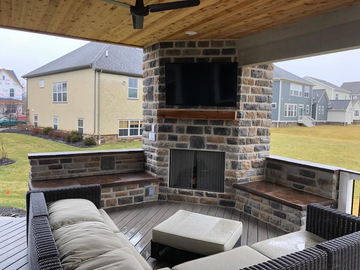 Couch and outdoor fireplace on covered porch