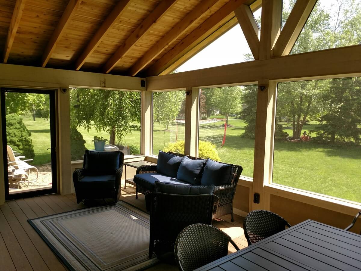 Cozy seating area on screened porch with backyard view